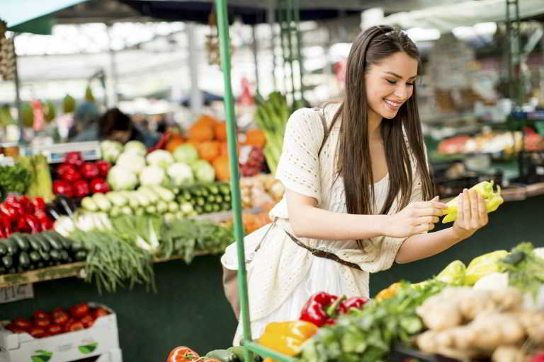 Young woman shopping fruits and vegetables on the market